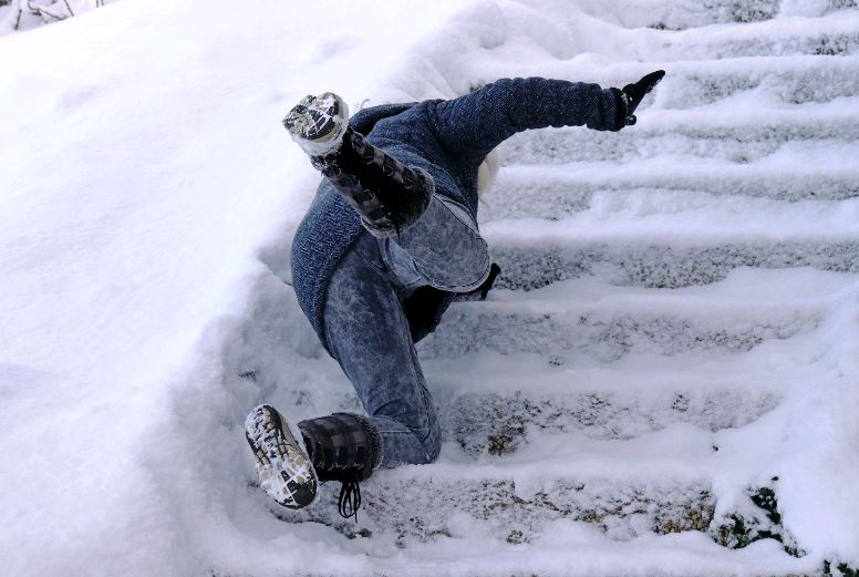 Person slipping and falling on snow covered steps.